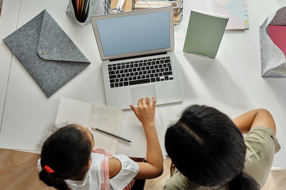 Osoba se soustředěně učí u notebooku s grafy a poznámkami.